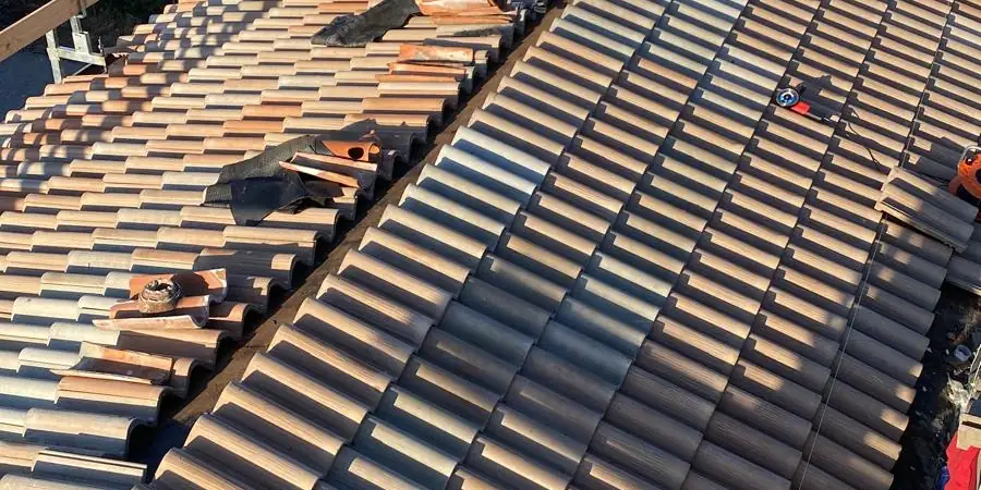 Tetto in rifacimento con tegole appena posate e parapetti in legno, luce della sera