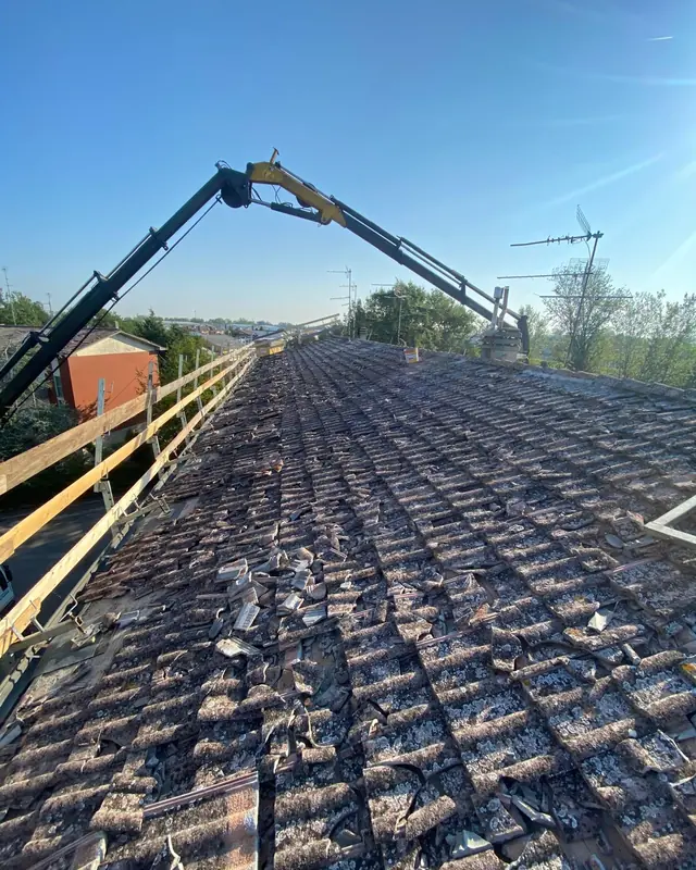 Smontaggio del vecchio manto con la gru Edilcoop sopra il tetto
