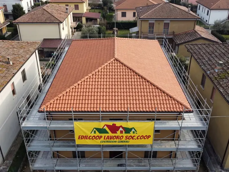 Villetta con il tetto appena rifatto da Edilcoop e telone Edilcoop sul ponteggio, vista dal drone